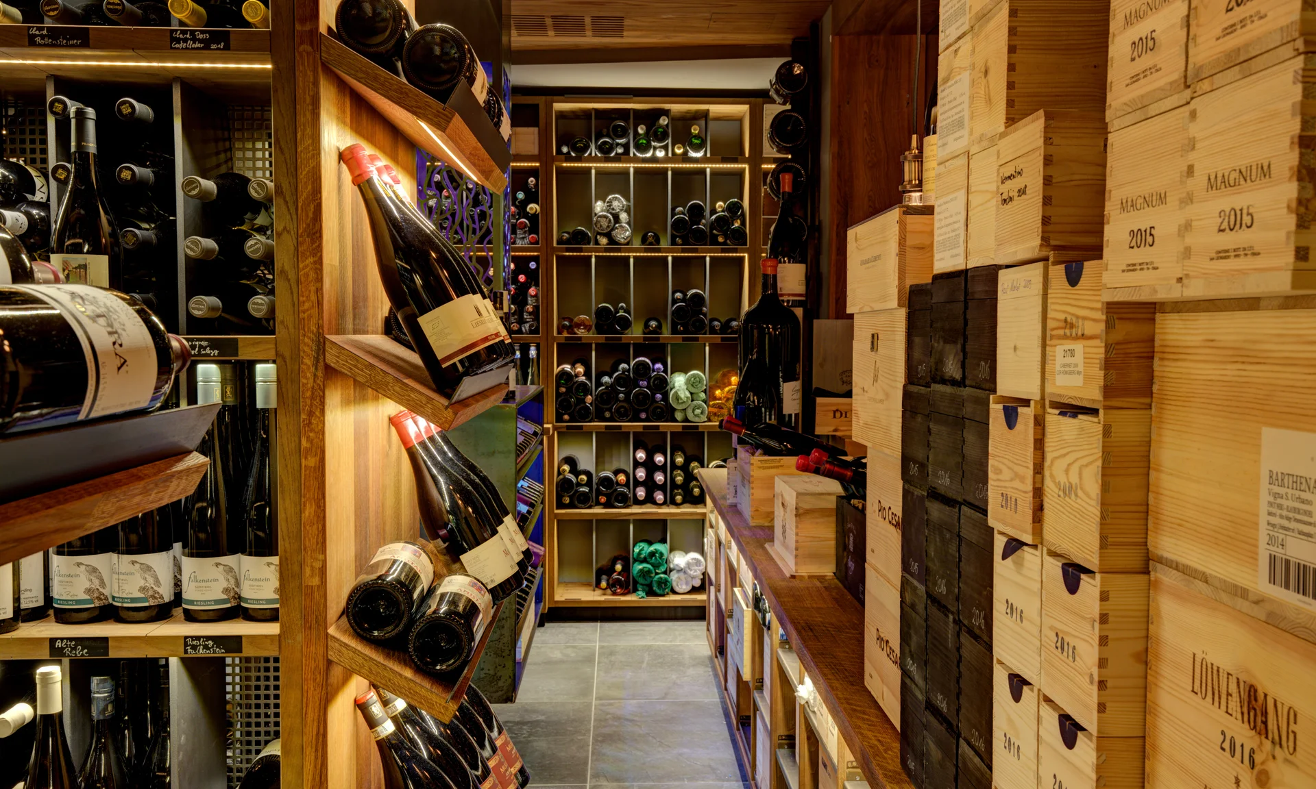 Entschleunigen und genießen in diesem Hotel nahe Bruneck Weinkeller mit Regalen voller Weinflaschen und Holzkisten