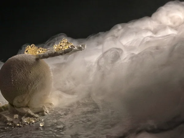 Entschleunigen und genießen in diesem Hotel nahe Bruneck Kunstvolles Dessert mit Kugel, Glasperlen und Nebeleffekt auf dunklem Hintergrund